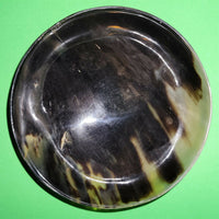 Polished buffalo horn bowl measuring 6" wide by 1 7/8" deep.