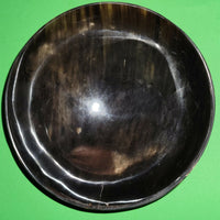 Polished buffalo horn bowl measuring 6" wide by 1 7/8" deep.