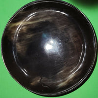 Polished buffalo horn bowl measuring 6" wide by 1 7/8" deep.
