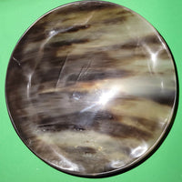 Polished buffalo horn bowl measuring 7" wide by 2 to 2-1/4" deep.