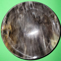 Polished buffalo horn bowl measuring 7" wide by 2 to 2-1/4" deep.
