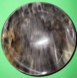 Polished buffalo horn bowl measuring 7" wide by 2 to 2-1/4" deep.