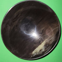 Polished buffalo horn bowl measuring 7" wide by 2 to 2-1/4" deep.