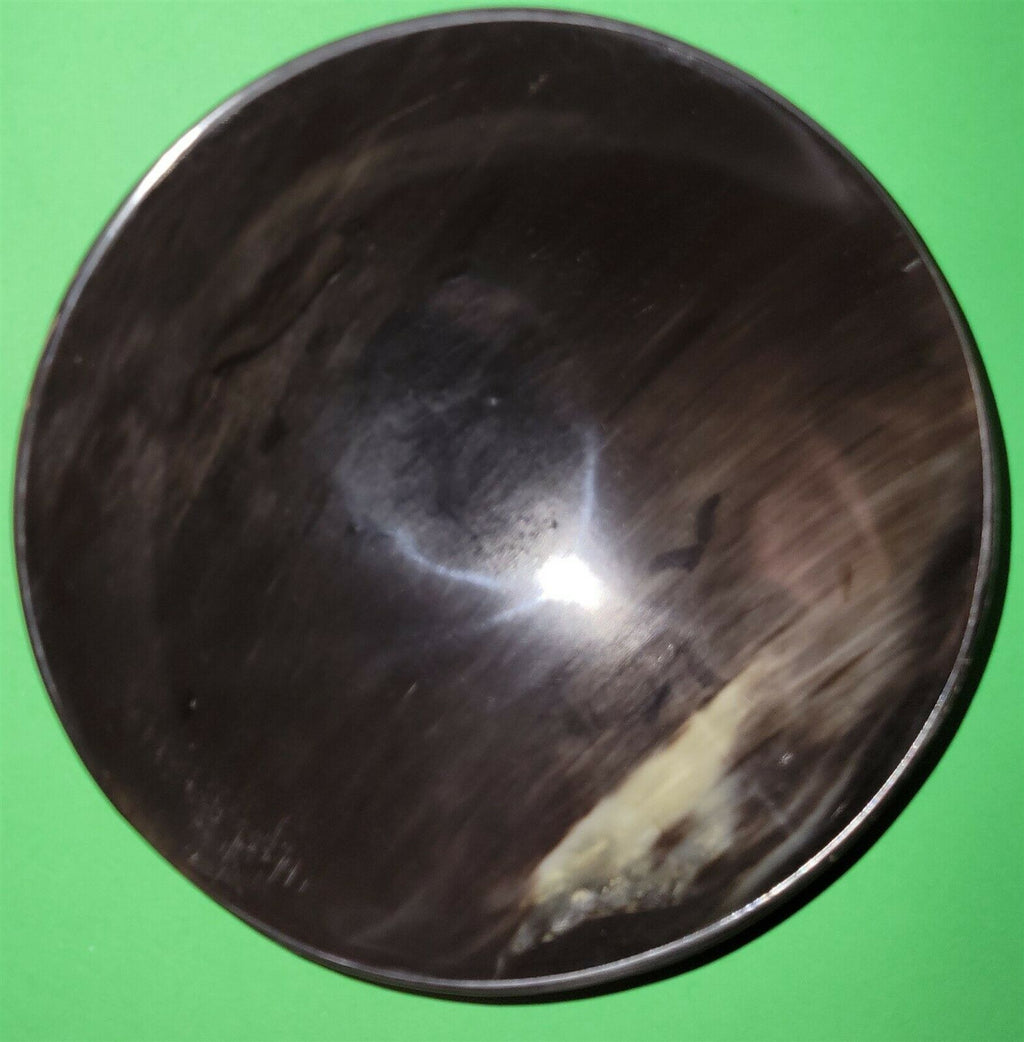 Polished buffalo horn bowl measuring 7" wide by 2 to 2-1/4" deep.