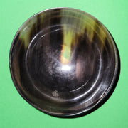 Polished buffalo horn bowl measuring 4" wide by 1 5/8" deep.