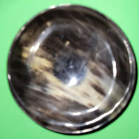 Polished buffalo horn bowl measuring 5" wide by 1 7/8" deep.