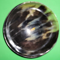 Polished buffalo horn bowl measuring 6" wide by 1 7/8" deep.